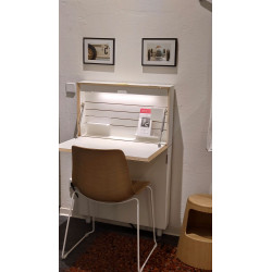 Schreibtisch Flatmate mit eingeschalteter Beleuchtung in der Ausstellung mit Stuhl